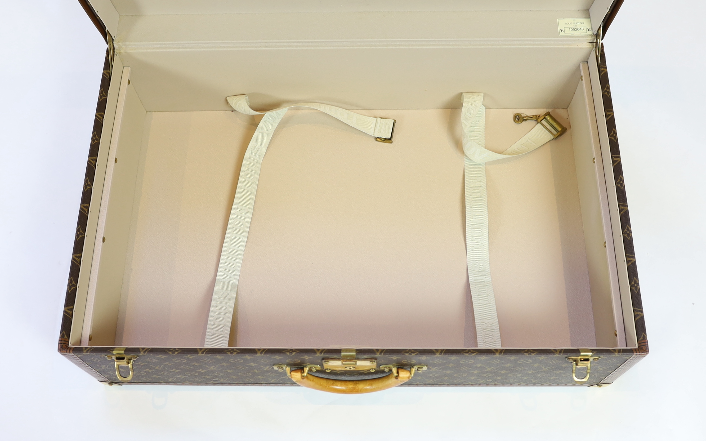 A Louis Vuitton monogrammed canvas and tan leather suitcase, 81cm wide, 26cm deep, 52cm high